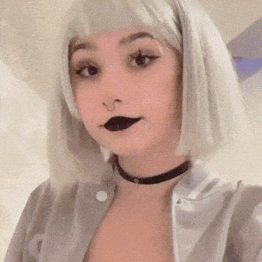 a woman with a nose ring and black lipstick is wearing a choker .