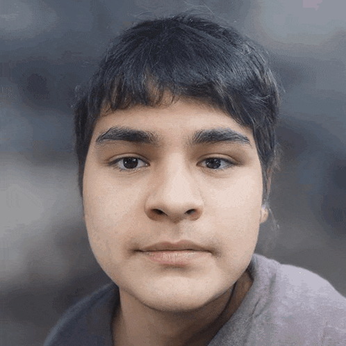 a close up of a young man 's face with a blurry background