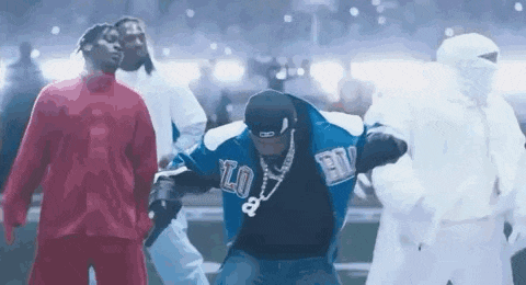 a group of men are dancing on a stage in a stadium .
