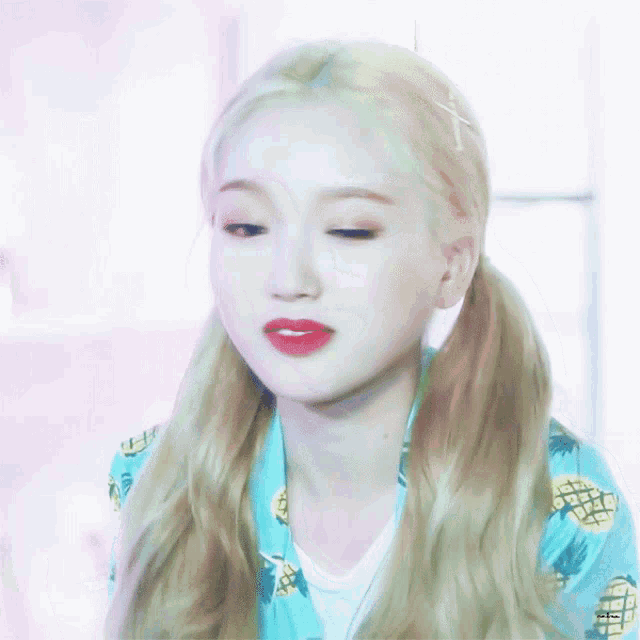 a woman with blonde hair and pigtails wearing a pineapple shirt