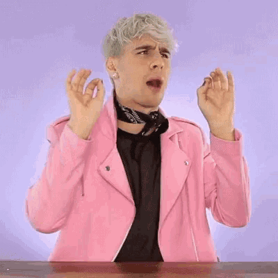 a man in a pink jacket is making a funny face and says `` amazing '' .