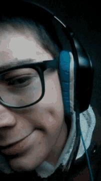 a man wearing glasses and headphones is laying down