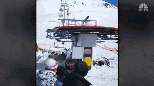 a group of people are waiting for a ski lift with a nbc news logo behind them
