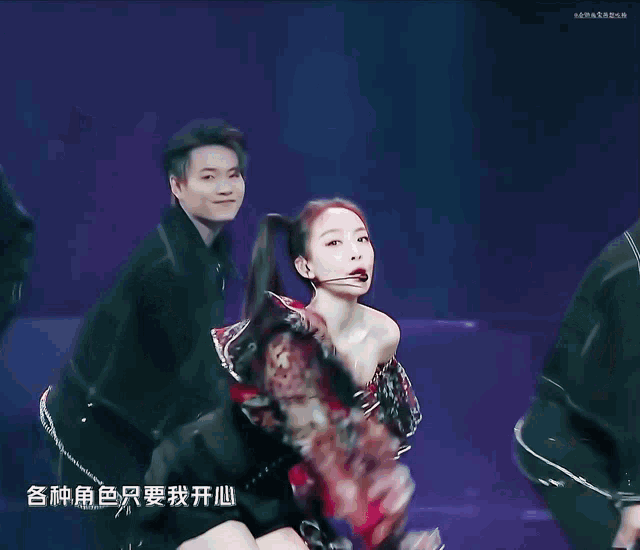 a woman in a red and black off the shoulder top is dancing
