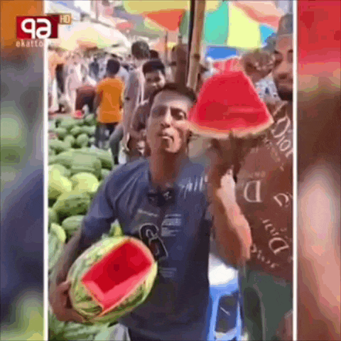 a man is holding a sliced watermelon in front of a crowd of people