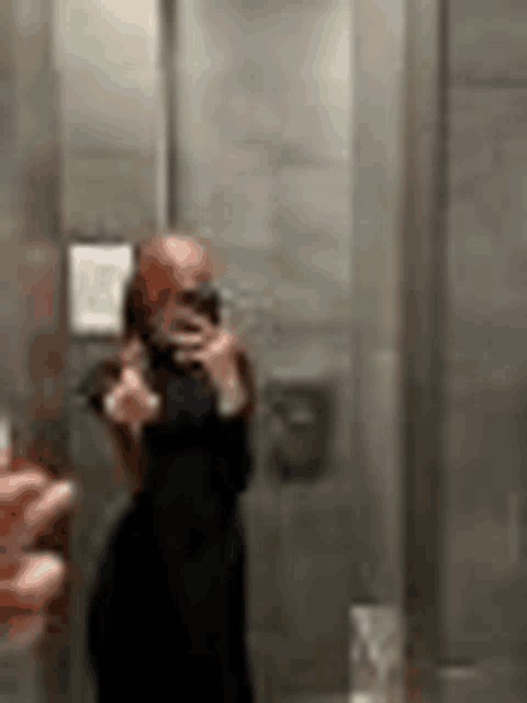 a woman is taking a picture of herself in a mirror .
