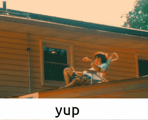 a man is sitting on the roof of a house with the word yup above him