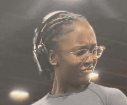 a woman wearing headphones and glasses is making a funny face