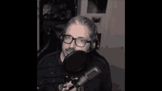 a man wearing glasses and headphones is in front of a microphone