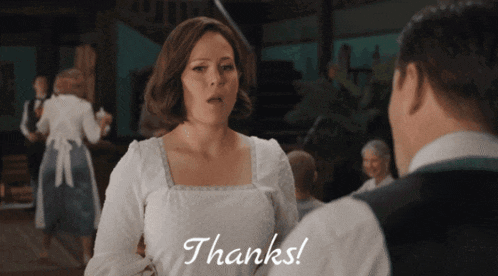 a woman in a white dress says thanks to a man in a vest