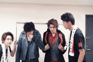 three young men are standing next to each other in a room .