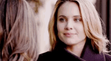 a woman in a purple coat looks at another woman