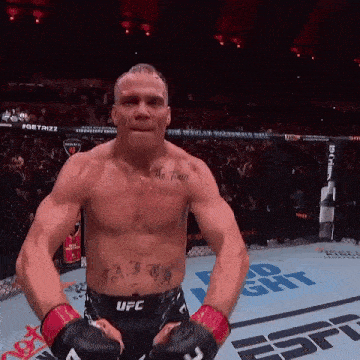 a man with a tattoo on his chest is wearing boxing gloves .