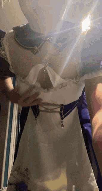 a woman taking a picture of herself in a white dress