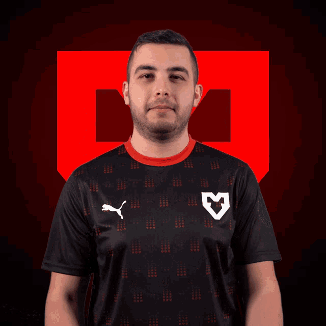 a man wearing a black shirt with a puma logo on the front