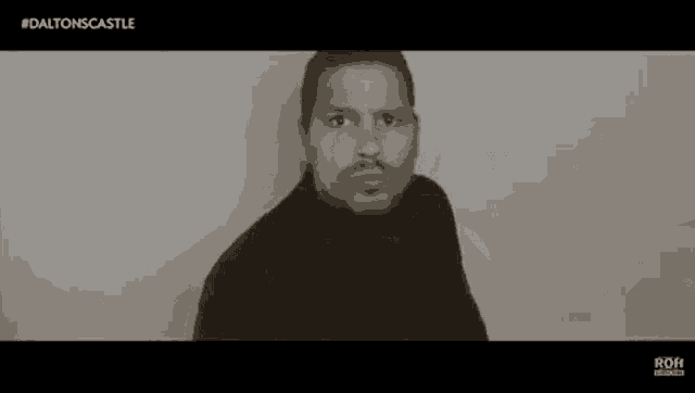 a man with a mustache wearing a black turtleneck sweater