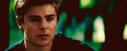 a close up of a young man 's face with tears running down his cheeks .