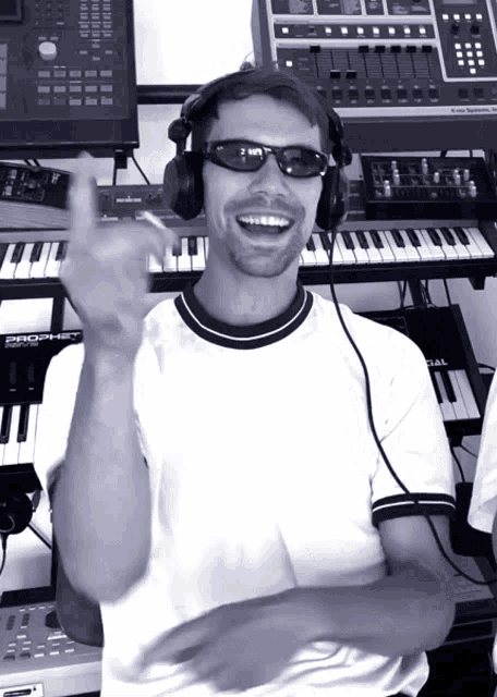 a man wearing headphones and sunglasses stands in front of a keyboard with the word prophet on it
