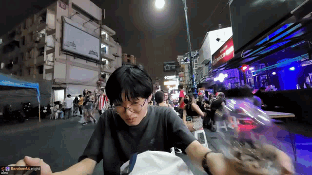 a man eating a hamburger in a crowded street with random64 night written in the corner