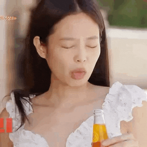 a close up of a woman holding a bottle of orange juice .