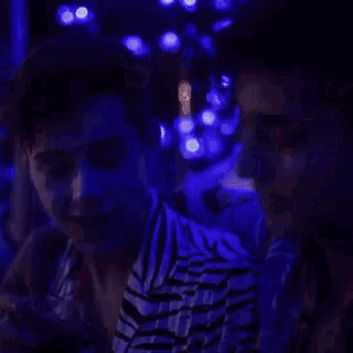 a man in a blue shirt is talking to another man in a black shirt