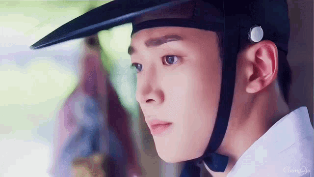 a close up of a man wearing a hat and looking at something .