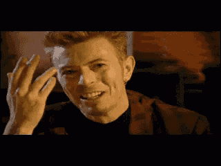 a close up of a man laughing with his hands in the air