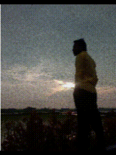 a silhouette of a person standing in front of a sunset sky