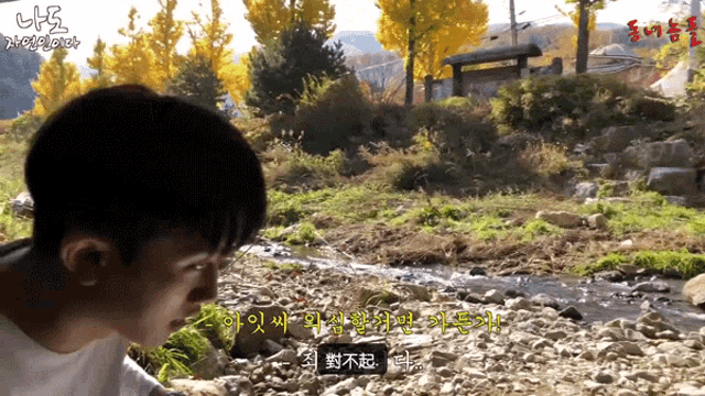 a man stands in front of a stream with chinese writing on the screen