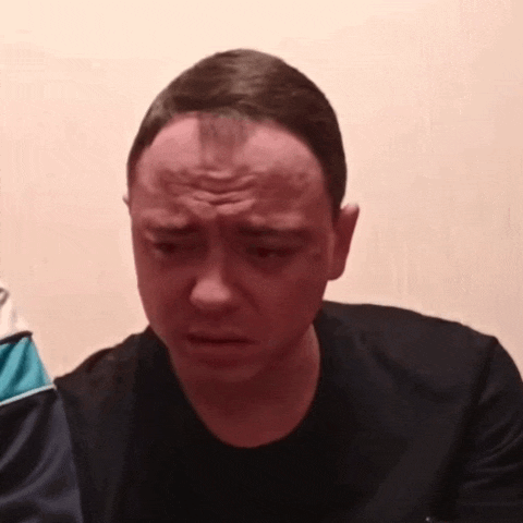 a man with a wig on his head is making a sad face