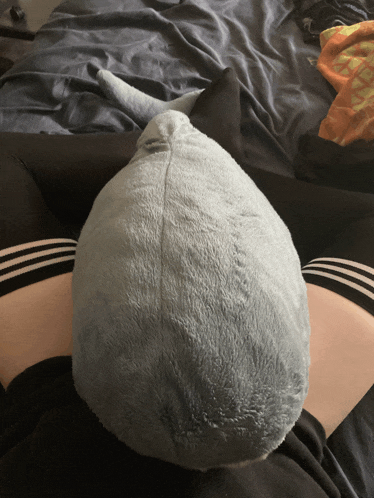 a person is laying on a bed with a stuffed animal in their lap