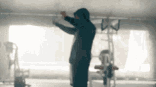 a man in a hooded jacket is standing in a room .
