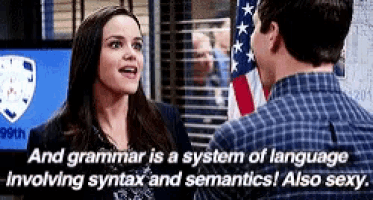 a man and a woman are talking in front of an american flag and grammar is a system of language involving syntax and semantics