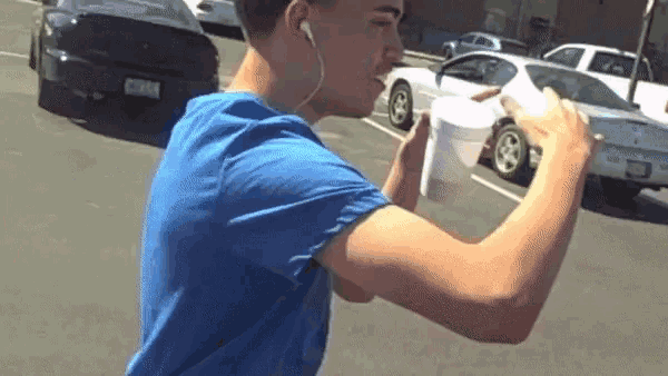 a man wearing ear buds is drinking from a cup