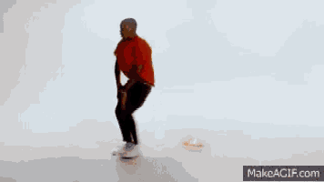 a man in a red shirt is standing in front of a pile of fried chicken .