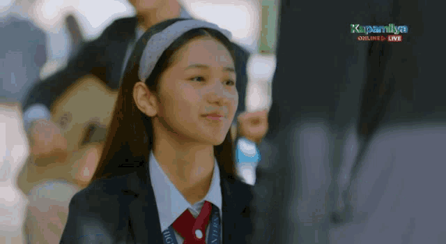 a girl in a school uniform with a lanyard that says international