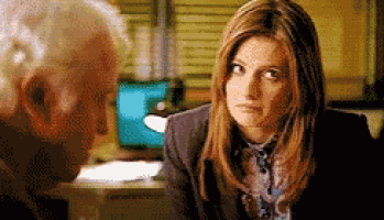 a man and a woman are talking to each other in a room
