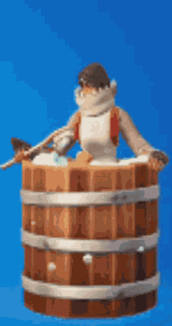 a cartoon character is sitting in a wooden barrel with a blue background .