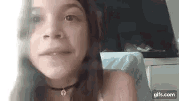 a young girl is making a funny face while wearing a choker .