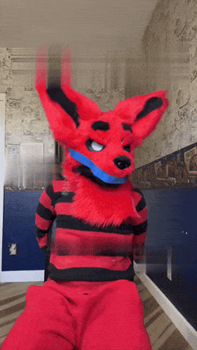 a person in a red furry fox costume is standing in a hallway