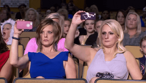 a woman taking a picture of another woman with a phone that says ' a ' on it