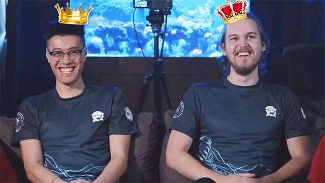 two men wearing crowns on their heads are smiling