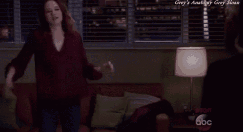 a woman is dancing in a living room with the words grey 's anatomy grey sloan written above her