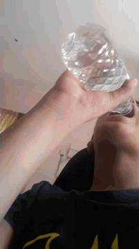 a person is holding a plastic bottle with their hand