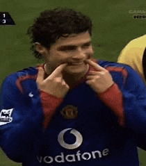 a man wearing a blue vodafone jersey is making a funny face .