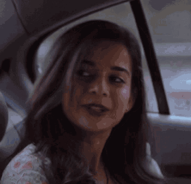 a woman is sitting in the back seat of a car looking out the window .