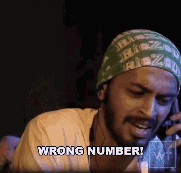 a man wearing a green bandana talking on a cell phone and saying wrong number
