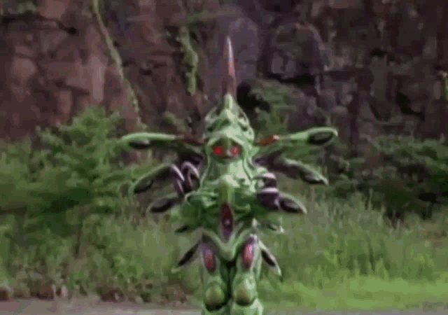 a green and purple monster with red eyes and purple tentacles is holding a baby .