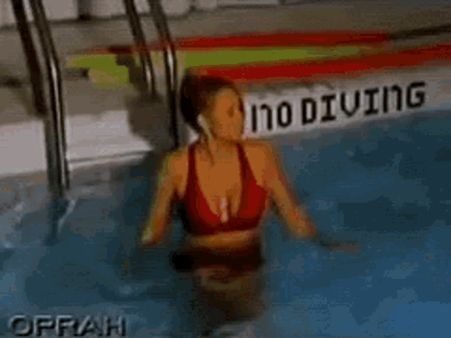 a woman in a red bikini is kneeling in a swimming pool that is 4 feet deep