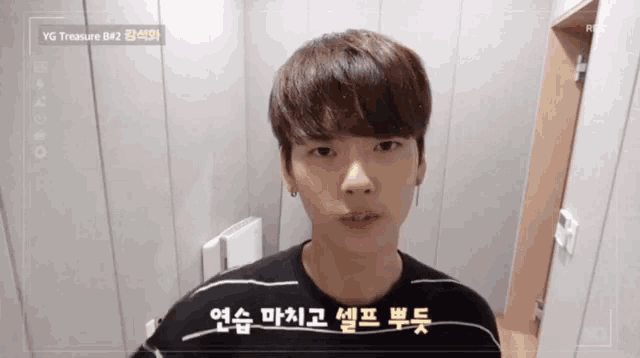 a young man stands in front of a camera that says yg treasure